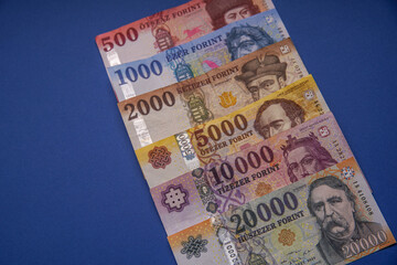 Several Hungarian forint paper money denominations on a blue background. Bank image and photo.