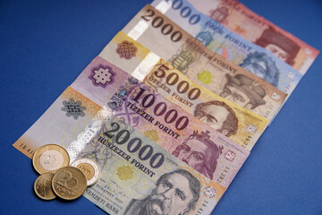 Several Hungarian forint paper money denominations on a blue background. Bank image and photo.
