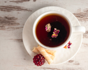 Herbal fruit tea with raspberry marmalade and wafer rolls, a cup of morning tea flat lay