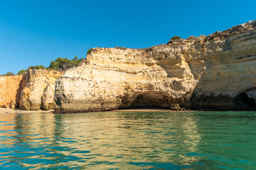 Natural caves and beach, Algarve Portugal. Rock cliff arches of Seven Hanging Valleys and turquoise sea water on coast of Portugal in Algarve region