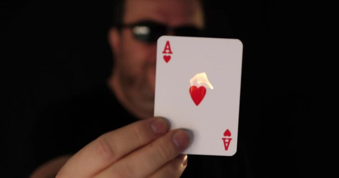 Card player presents burning ace of hearts in his hand.