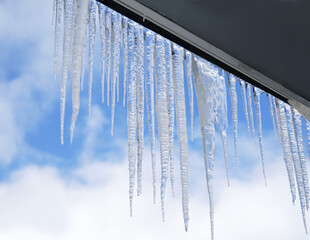 icicle hanging under the roof outside the house