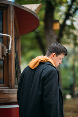 Young man in formal clothes walks in the autumn park.