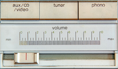 closeup of some of the controls on an old stereo system. Volume slider below input controls. Text...