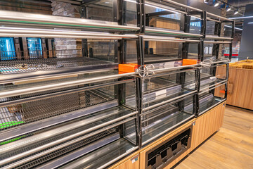 Empty commercial fridges at grocery store. Empty shelves in a supermarket amid the coronavirus pandemic. Sold out frozen food section