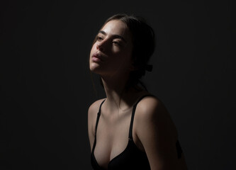 Sensual girl profile portrait. Nude makeup. Silhouette girl in bra. Female in black underwear.