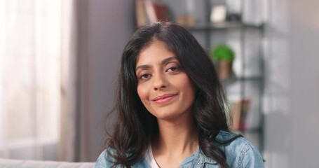 Close up portrait of cheerful happy young pretty female looking at camera and smiling in good mood, Hindu pretty woman with smile on face in modern apartment alone, positive emotions concept