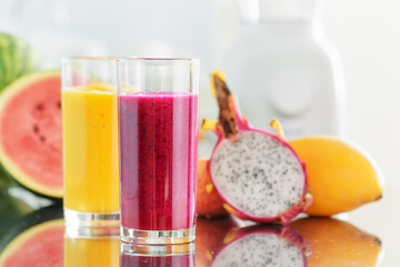 Fresh fruit smoothies on kitchen table. Blender in background