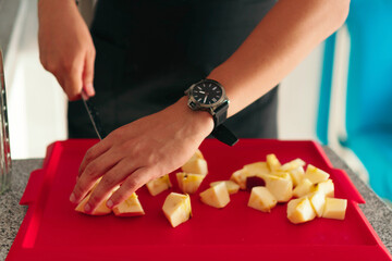 Anonymous man cutting an apple. Close-up photo