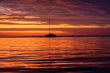 Summer vacation traveling. Ocean yacht sailing. Boat on the sea. Sailboats at sunset.