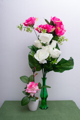 vase with pink flowers and green leaf.
