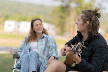 Naklejka premium A couple sitting in portable chairs in camping park