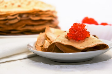 thin pancakes with red caviar on white napkin. The concept of the Russian carnival Maslenitsa