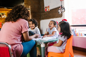 hispanic mother with her daughters at home in homeschooling concept in Mexico