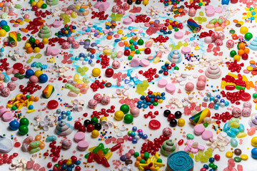 Fototapeta na wymiar Confectionery and chocolate coated candies on the table. Variety of holiday sweets, lollipop, candy beans, marshmallows, colourful gummy, sugar dessert swirls, Liquorice on the table.