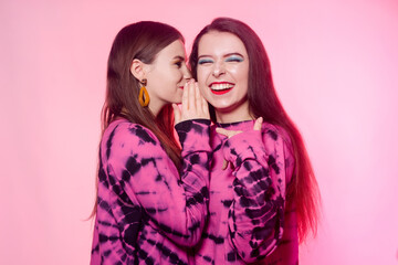 2 girls in the same things with bright makeup. Brunette girls, sisters, girlfriends, twins gossip, discuss, laugh. Women's power, March 8, Women's Day. copy space