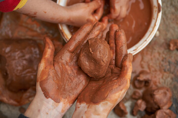 Fototapeta premium woman holding clay ball with both hands.
