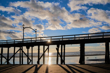 Setting sun appears as star on silhouetted White Rock Pier
