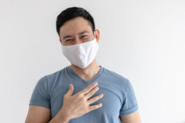 Happy and pleased expression of Asian man in white mask on isolated background.