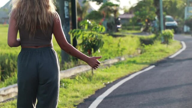 Hitchhiking Attractive girl traveler stops the car on the road.
