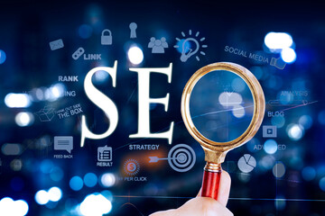 Close up of man hand using magnifier with SEO word