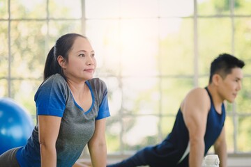 Adult asian man and woman family wearing sport outfit do exercise workout yoga for healthy self care at home