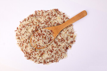 Mixed low glycaemic index healthy rice grain basmati millet buckwheat red rice heap wooden spoon on white background top view