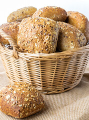Freshly baked bread. Fresh loaf of rustic traditional bread with wheat grain ear or spike plant on linen texture background. Rye bakery with crusty loaves and crumbs. Healthy Food concept.