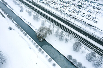 parking lot near frozen water canal on chilly winter day. aerial view from above
