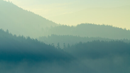 Mountain layers during sunrise in foggy morning. British Columbia, Canada.