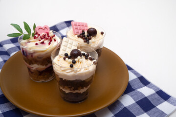 Trifles portioned mini cakes on plate. Layered trifle dessert with whipped cream and chocolate