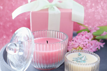 scented candles and hyacinth flower on a cement tray and a gift box. cosy home concept. holiday selebration and present. fragrances for house atmosphere. 