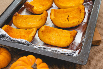 Roasted pumpkin slices close up on baking pan, homemade pumpkin puree recipe