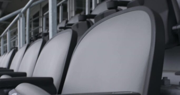 Close shot of empty stadium seats in slow motion with movement up and to the right.