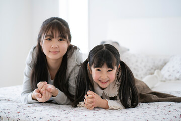 ベッドの上でくつろぐ日本人姉妹