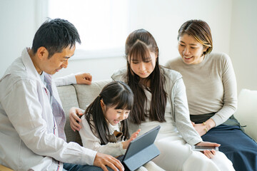 タブレットPCを見る日本人家族 © arc image gallery