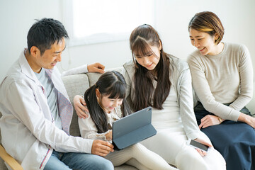 タブレットPCを見る日本人家族 © arc image gallery
