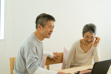 Obraz premium ノートパソコンを見るシニア夫婦