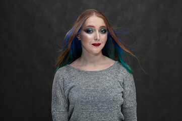 Portrait of a caucasian model with bright makeup and long hair on a black background