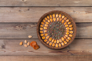 Nutty gluten-free cake with apricot nuts on a brown wooden background. Copy space.