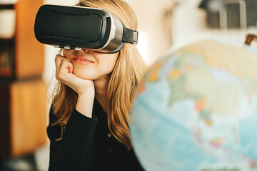 Pretty woman using vr headset and world map dreaming of travel to any destination while lockdown