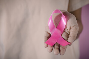 womaen hand holding pink ribbon breast cancer awareness. concept healthcare and medicine. cancer concept