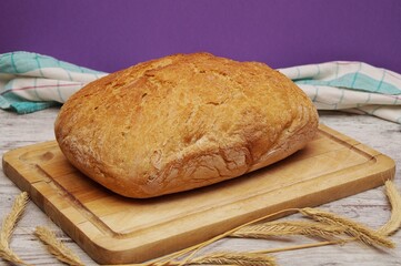 a freshly baked home-baked loaf of bread lying on a cutting board 