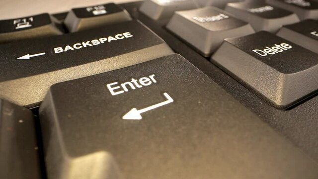 Backspace and Enter buttons with white arrow signs on computer black keyboard under bright light extreme closeup. Concept text message