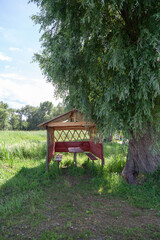 Outdoor wooden gazebo on sunny summer day
