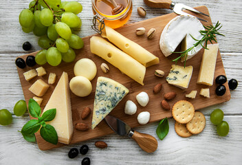 Fototapeta na wymiar Various types of cheese on a white wooden background