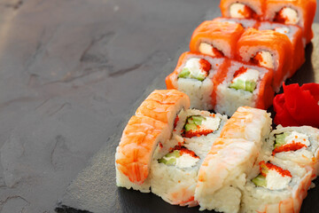 Set of various sushi rolls served on gray background