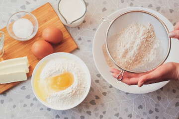 Sifting flour. Ingredients for homemade pancakes. Cooking for someone special concept. Top view