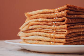 Stack of Russian pancakes with honey, closeup. Maslenitsa and crepe week concept