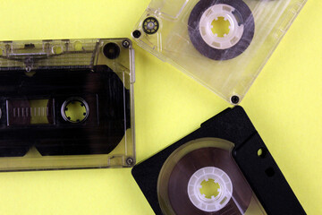 Three audio cassettes on a yellow background